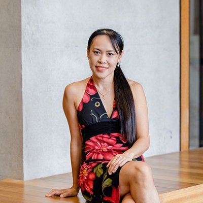 A woman sitting cross-legged in a black and red dress